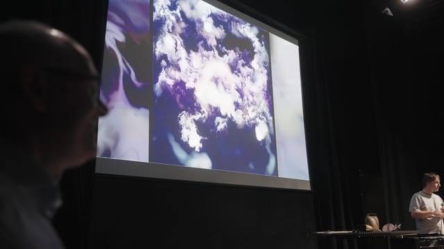Performance still from Fingerprints at The MAC, Belfast, showing musicians and projection in the theatre space.